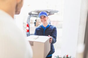 cheerful courier giving package to client